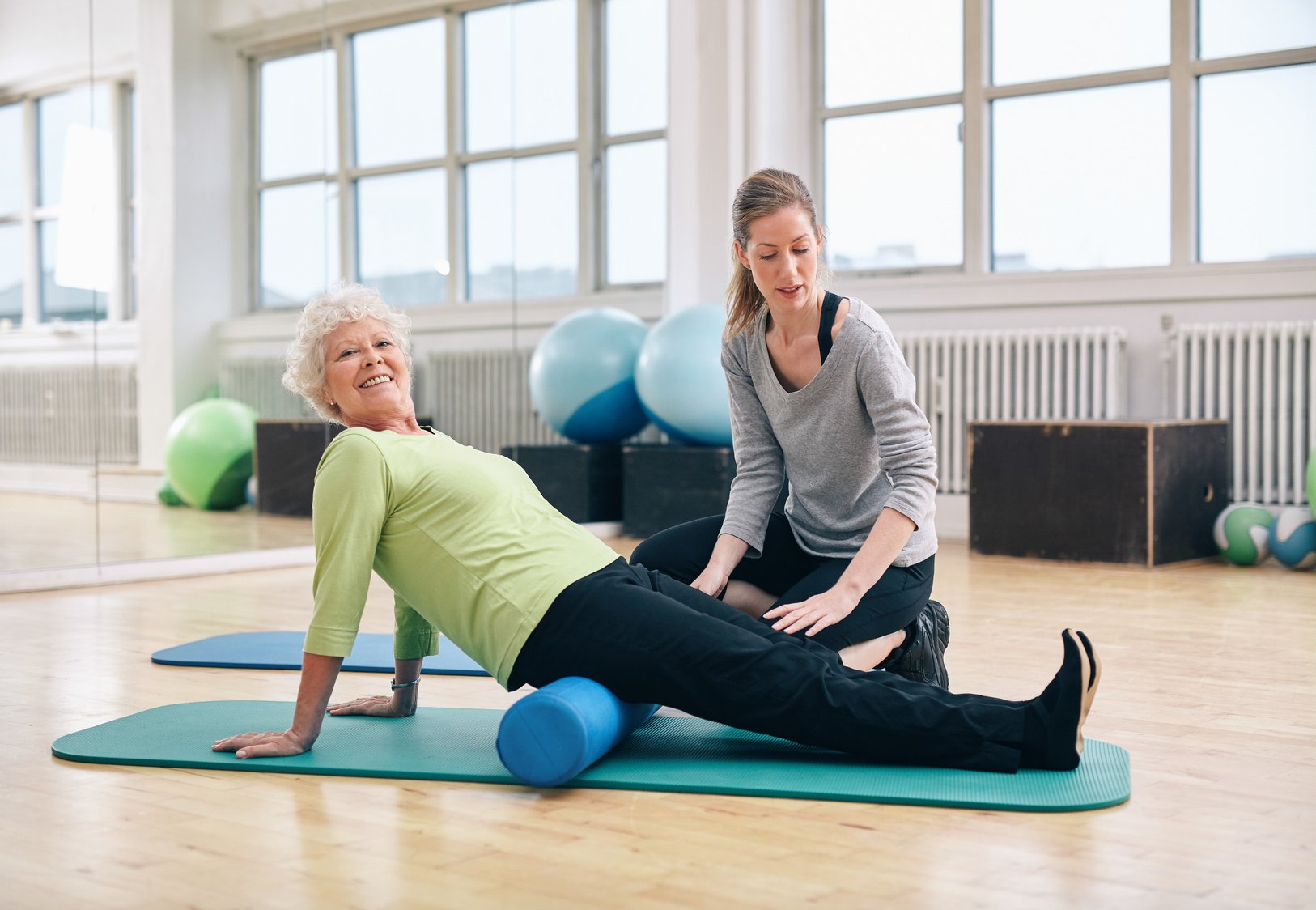 Senior Woman Doing Pilates with Foam Roller